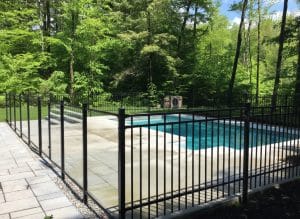 Clôture ornementale noire en aluminium avec barrière d'accès sécurisant une piscine creusée